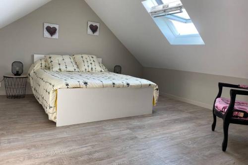 a bedroom with a white bed and a skylight at Maison de pêcheur à 10 minutes de la plage à pieds in Cayeux-sur-Mer