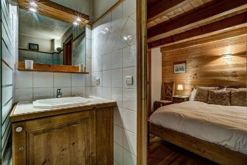 La salle de bains est pourvue d'un lavabo et d'un lit dans la chambre. dans l'établissement MGM Parc Couttet, à Chamonix-Mont-Blanc