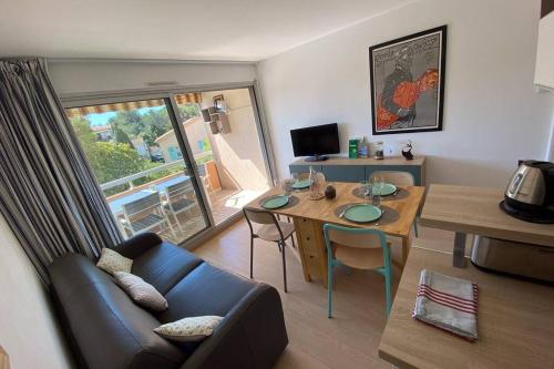 un salon avec une table et un canapé dans l'établissement St-Raphaël - joli T1 au port de Santa-Lucia, à Saint-Raphaël