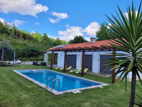 a swimming pool in the yard of a house at Casa da Quinta do Sóto in Terras de Bouro