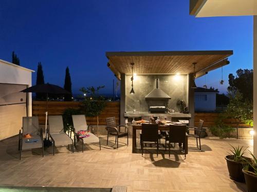 a patio with a table and chairs and a grill at Shanti Paphos Villa in Paphos City