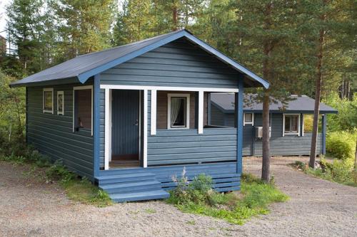 a blue building with a porch and a door at Kolbacken stugby & Camping in Åsarne