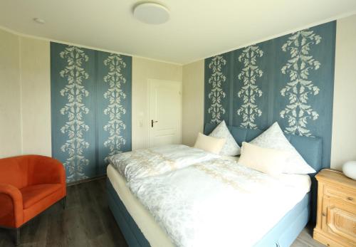 1 dormitorio con 1 cama y 1 silla naranja en Villa Alta, en Bad Wildungen