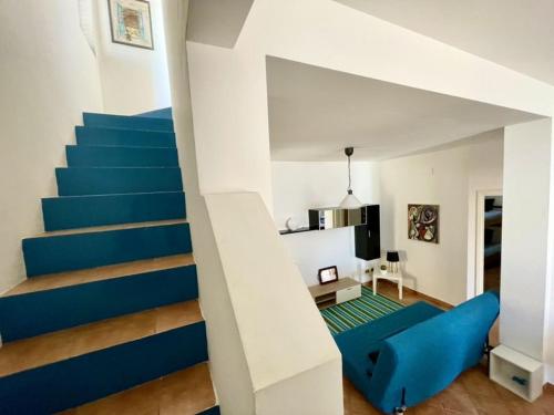 uma sala de estar com um sofá azul e escadas em Apartment in the center em Terrasini