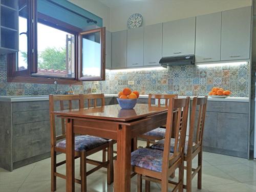 a kitchen with a wooden table and chairs with oranges on it at Casa di Rena in Nafplio