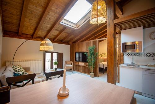 a kitchen and living room with a skylight at Apartamentos UXAMA LUXURY EPONA - junto a la Plaza Mayor con ascensor in El Burgo de Osma