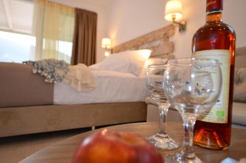 a bottle of wine and two glasses on a table at Meltemi Studios in Vasiliki
