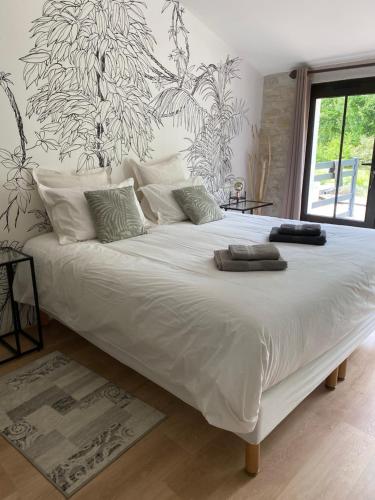 a large bed with white sheets and pillows on it at La Chaumeauniere in Aigrefeuille-dʼAunis