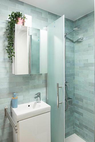 a bathroom with a white sink and a shower at Mar de Fondo in Barbate