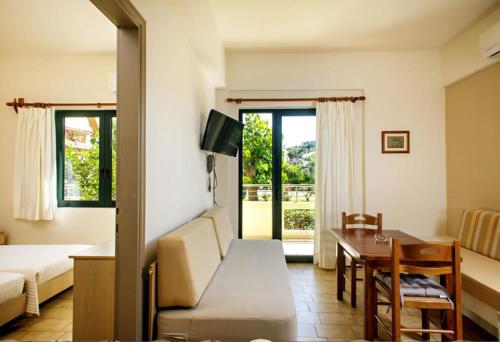 un soggiorno con letto, tavolo e divano di Lili Apartments,oasis 2,5 km from Hania center a Parigoría