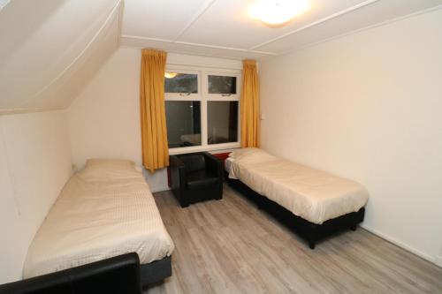 a small room with two beds and a window at Hof Suzanna in Arnemuiden