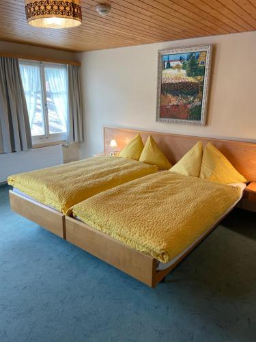 1 dormitorio con 1 cama grande con mantas y almohadas amarillas en Landgasthof Schäfle, en Sankt Peterzell