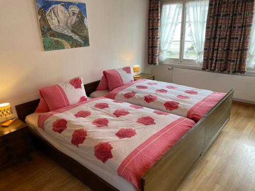 a bedroom with two beds with red flowers on it at Landgasthof Schäfle in Sankt Peterzell