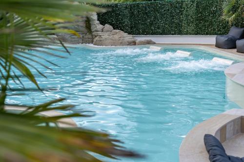 a swimming pool with blue water and a waterfall at Avaton Luxury Resort and Spa Access the Enigma - Adults Only & Kids 14 Plus- in Asprovalta