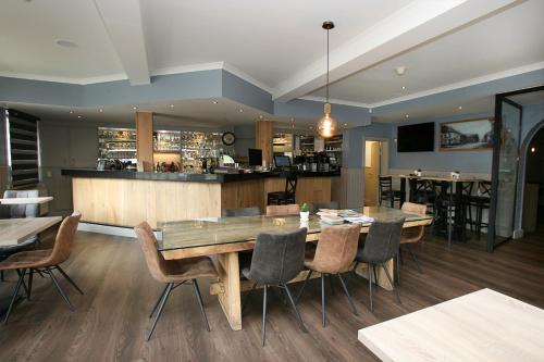 a dining room with a table and chairs and a bar at Hotel Au Prince Royal in Leopoldsburg