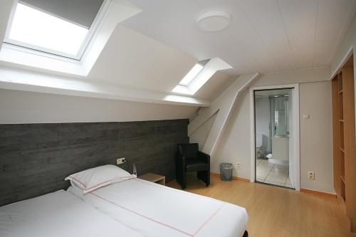 a bedroom with a bed and a skylight at Hotel Au Prince Royal in Leopoldsburg