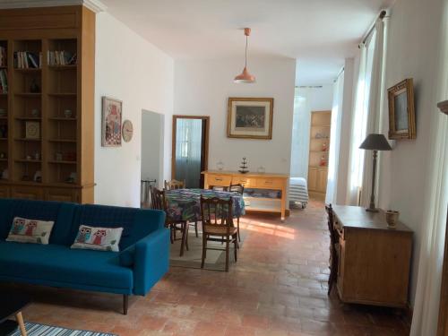 un salon avec un canapé bleu et une table dans l'établissement Château Tallavignes, à Fabrezan