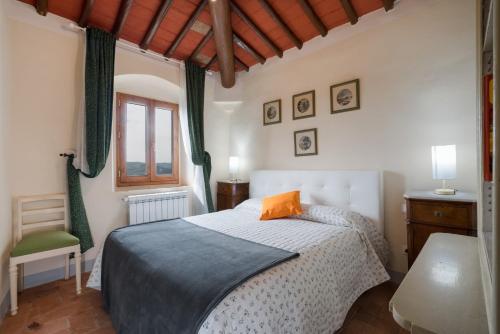 Schlafzimmer mit einem Bett und einem Fenster in der Unterkunft Casa ALTA in Greve in Chianti