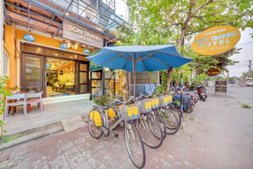 a group of bikes parked in front of a building with an umbrella at Son Trang Hotel Hoi An in Hoi An