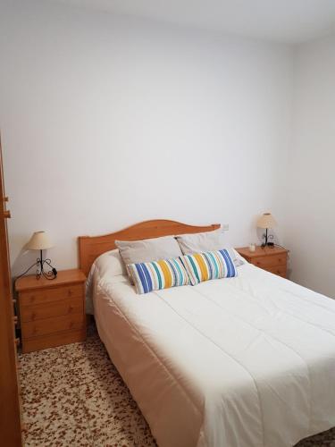 una camera con un letto bianco con due cuscini di Chalet Playa de Barbate a Vejer de la Frontera