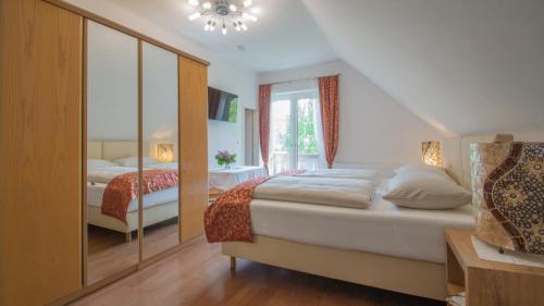 a bedroom with two beds and a large window at Gästehaus Dobernig in Sankt Niklas an der Drau