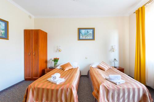 two beds in a hotel room with towels on them at Salis Resort in Wieliczka