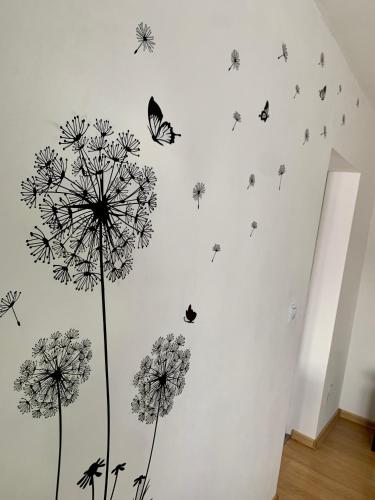 a wall with dandelions and butterflies on it at MaHome Apartments in Lofer