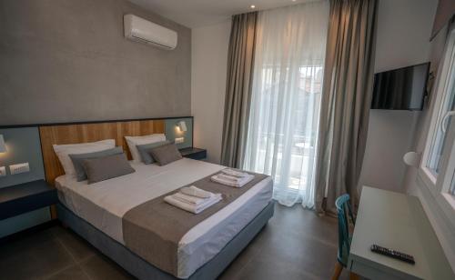 a bedroom with a large bed with towels on it at Tompazi 2 in Kavala