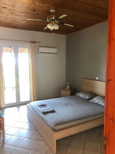 a bedroom with a bed and a ceiling fan at Aggeliki House 5 in Kómboi
