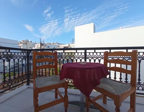 een tafel en 2 stoelen op een balkon bij Ammosis Inn in Naxos Chora