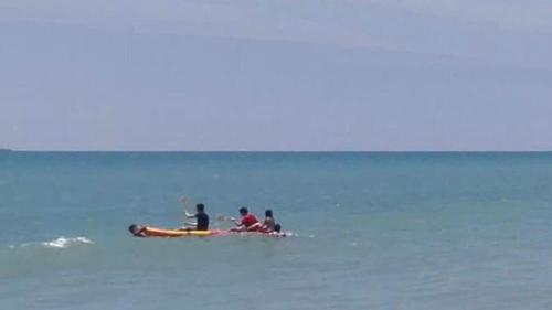 three people sitting on a boat in the water at Las palmeras de bocapan in Tumbes