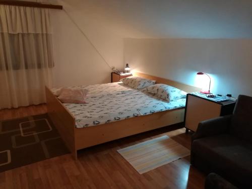 una camera con letto, lampada e divano di Raslina Sun Apartment a Raslina