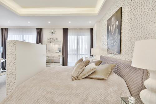 a white bedroom with a bed with gold pillows at Fabulous Studio with Stunning Sea View by MK2 in Dubai