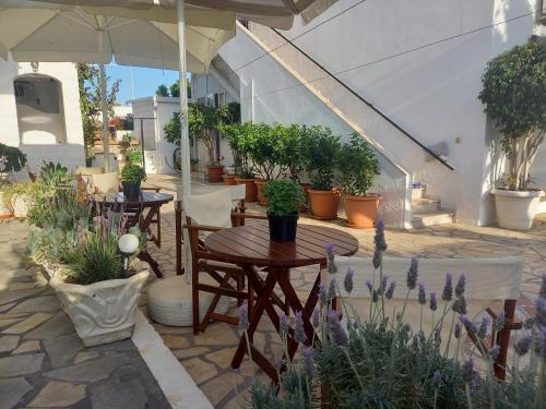 a patio with tables and chairs and potted plants at Stefanos Katsaros Studios in Skala