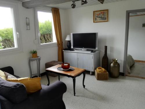 a living room with a tv and a coffee table at Les gîtes de "La Quesnoyère" in Quesnoy-le-Montant