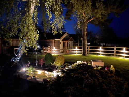 une maison éclairée dans la cour la nuit dans l'établissement Field's Edge, à Swinderby