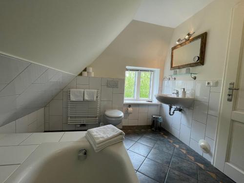 ein Badezimmer mit einer Badewanne und einem Waschbecken in der Unterkunft Gästehaus Zum Krug in Husum