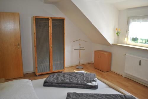 a bedroom with a bed and a closet and a window at Ferienwohnungen am Plätlinsee in Wustrow