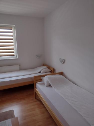 a bedroom with two beds and a window at Zlatni San in Banja Koviljača