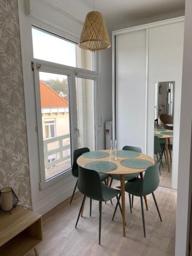une salle à manger avec une table et des chaises et une fenêtre dans l'établissement Appart wimereux centre, à Wimereux