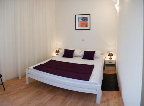 una camera con un letto bianco e due comodini di Room PlaceForYou a Dubrovnik