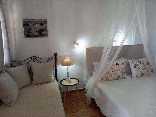a bedroom with two beds and a table with a lamp at Stefanos Katsaros Studios in Skala