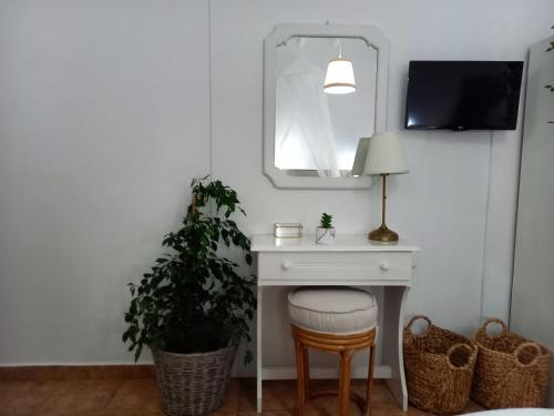 a desk with a lamp and a plant and a mirror at Stefanos Katsaros Studios in Skala