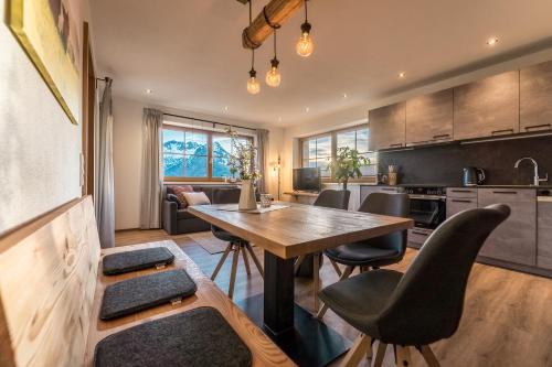 eine Küche und ein Esszimmer mit einem Holztisch und Stühlen in der Unterkunft Bio Bauernhof Oberhinterberg Appartement in Annaberg im Lammertal