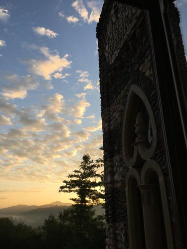 a building with a tree in front of a sunset at Bed&Box in Gassino Torinese