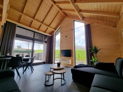a living room with a couch and a table at Chalet aan de Oosterschelde met Airconditioning! in Sint Annaland