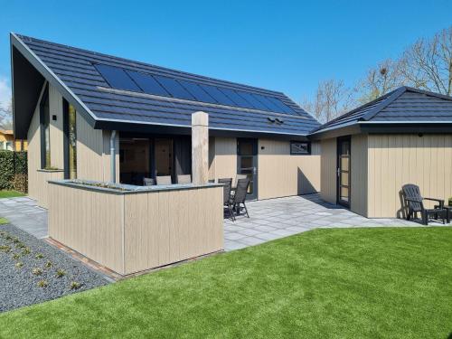 a house with solar panels on the roof at Chalet aan de Oosterschelde met Airconditioning! in Sint Annaland