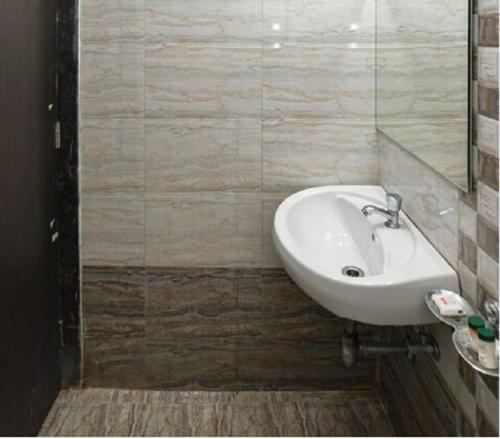 a bathroom with a white sink and a mirror at Nanndi Holiday stay in Kīhīm