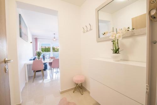 een kamer met een spiegel en een tafel met roze stoelen bij Romanca in Zadar