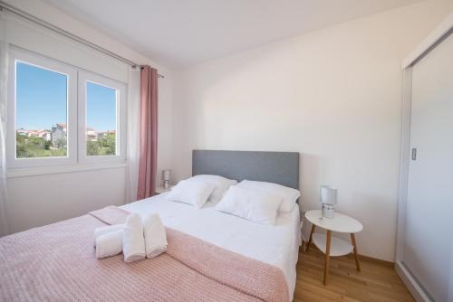 a white bedroom with a large bed with white pillows at Romanca in Zadar